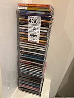 Stack of CDs featuring The Beatles 'LOVE' along with other music albums stacked against a white wall.