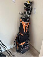 Front view of E21 orange and black golf bag with assorted right-handed clubs inside
