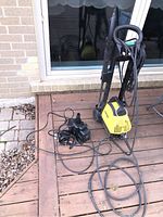 Full view of Karcher power washer and black pond pump on ground outdoors, shows size and condition.