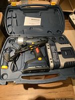 Cordless drill, battery pack, auxiliary handle, manual inside hard plastic case.