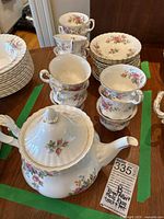 Teapot with floral Moss Rose pattern and matching cups and plates around it