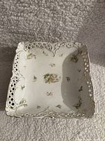 Top view of square Bavarian porcelain bowl showing pierced lattice rim and hand-painted floral design inside bowl.