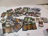 Wide view of many Magic the Gathering cards laid out loosely showing both front and back sides.