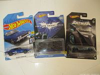 Front view showing all three Hot Wheels cars in original packaging including '69 Dodge Charger 500, The Bat, and Batman Batmobile.