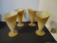 Four glasses styled to look like waffle cones, arranged on a surface, showing their shape and color