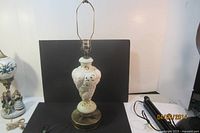 Full view of the vintage Capodimonte porcelain table lamp with light cream and gold accents, showing the overall body, base, and lamp holder.