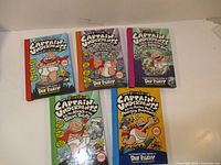 Five Captain Underpants books laid out showing covers with full-color illustrations and titles.