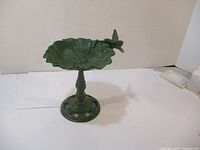 Green cast iron bird bath photographed indoors showing full profile and hummingbird detail