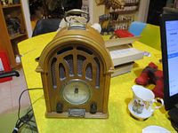 Full view of the Daklin Museum Series AM/FM radio wooden cabinet with rounded top and front vintage grill design placed on yellow surface.