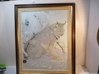 Full view of framed snow leopard artwork in mostly grey and white tones, showing the animal in a snowy setting.