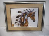Framed print of mare and colt with feather adornments, displayed on wall, showing overall artwork and frame.