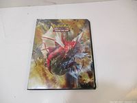 Black Pokemon Trading Card Game binder featuring red and blue Gyarados artwork on front cover.