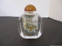 Front side of the hand painted clear crystal bottle showing detailed tiger and landscape design with a brown stopper.