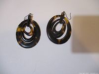Pair of vintage tortoise shell style earrings shown front view with concentric oval loops.