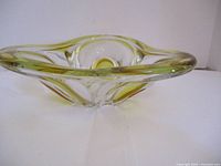 Side view showing curved edges and yellow tint at rim and designs inside bowl.