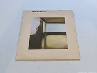 Front cover of Dire Straits Self Titled LP showing album artwork of a figure in a room with window light and the band's name printed on top.