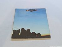 Front cover of Eagles self-titled LP showing blue sky and silhouetted band members with Eagles logo