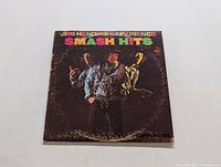 Front cover of Jimi Hendrix Experience Smash Hits LP showing the band members and colorful title with wear around edges.