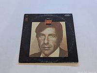 Front cover of the Leonard Cohen self-titled vinyl LP album showing sepia-toned photo of Leonard Cohen.