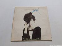 Front cover of Lou Reed's "Coney Island Baby" album showing Lou Reed holding a hat in front of half his face with visible wear and a blue pen mark.