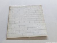 Front cover of Pink Floyd The Wall gatefold LP showing white brick wall design.
