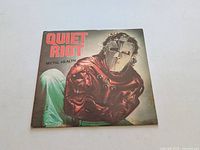 Front cover of Quiet Riot Metal Health vinyl LP record showing masked figure in red jacket.