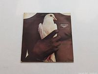 Front cover of Santana Greatest Hits LP showing hand holding white dove.
