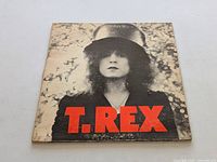 Front cover of T. Rex The Slider vinyl LP showing the artist with top hat and red letters.