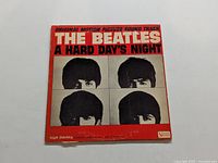 Front of album cover of 'A Hard Day's Night' by The Beatles with text and band member photos.