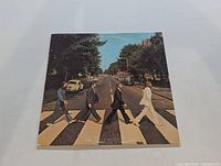 Front album cover showing The Beatles walking across Abbey Road zebra crossing in London.