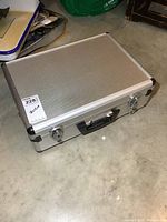 Aluminum case closed, sitting on floor showing front and top