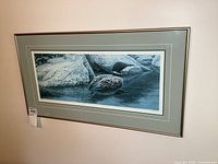 Framed print of a loon swimming near rocks, with visible price tag 286