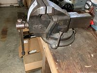 Side view of the vintage Record No. 5 bench vise mounted on a workbench showing the tightening handle and visible wear.
