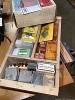 Wooden box with assorted yellow Lee Valley router bit packs and red bit blocks