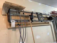 Craftsman Router Crafter mounted horizontally on wall with attached manual and bungee cords visible.