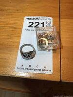 Birks sterling silver men's ring and a small plastic case containing NT award pins on a numbered card.