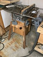 Full view of vintage Craftsman table saw on wooden stand in a garage.