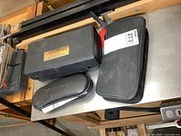 Overview image showing three closed cases containing the lot items on a metal surface.