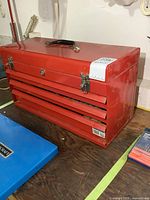 Closed view of red Mastercraft metal toolbox with top handle, showing condition and size.
