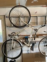 Side view of the vintage Glider men's 3-speed bicycle hanging on a wall, showing the full frame including tires, seat, pedals, and chain.