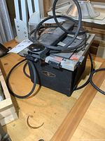 Full view of the black metal vintage darkroom viewer lamp showing circular top frame and attached power cord.