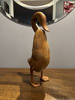 Front view of the handcrafted bamboo wood duck figurine with curved neck and detailed feet.