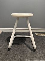 Front view of white tubular steel postmodern stool showing round seat and frame shape.