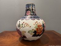 Front view of the vintage Chinese hand-painted cloisonné porcelain vase showing the floral and ornamental designs on bulbous body and neck.