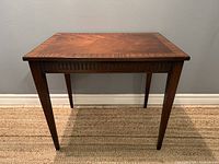 Front view of the mahogany side table showing rectangular shape and tapered legs.