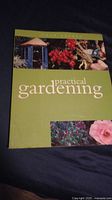 Front cover of Practical Gardening book showing garden images and title.