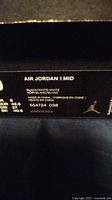 Close-up photo of the shoe box label showing Nike Air Jordan 1 Mid, black/white color, size 9 US