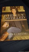 Front cover of the hardback whiskey book showing title, author, and photo of woman holding whiskey glass.