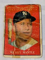 Front view of 1961 Topps Mickey Mantle MVP card showing heavy creases, wear and corner damage.