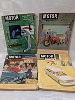 Four vintage Motor Magazine issues from 1962 to 1964 with automotive and motorcycle themed covers, showing wear and discoloration.